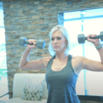 a women holding two dumbells